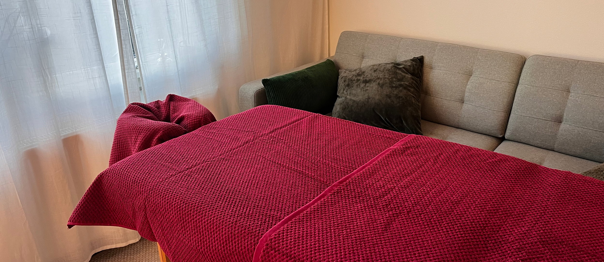 photo of massage table inside of home with purple-red towels